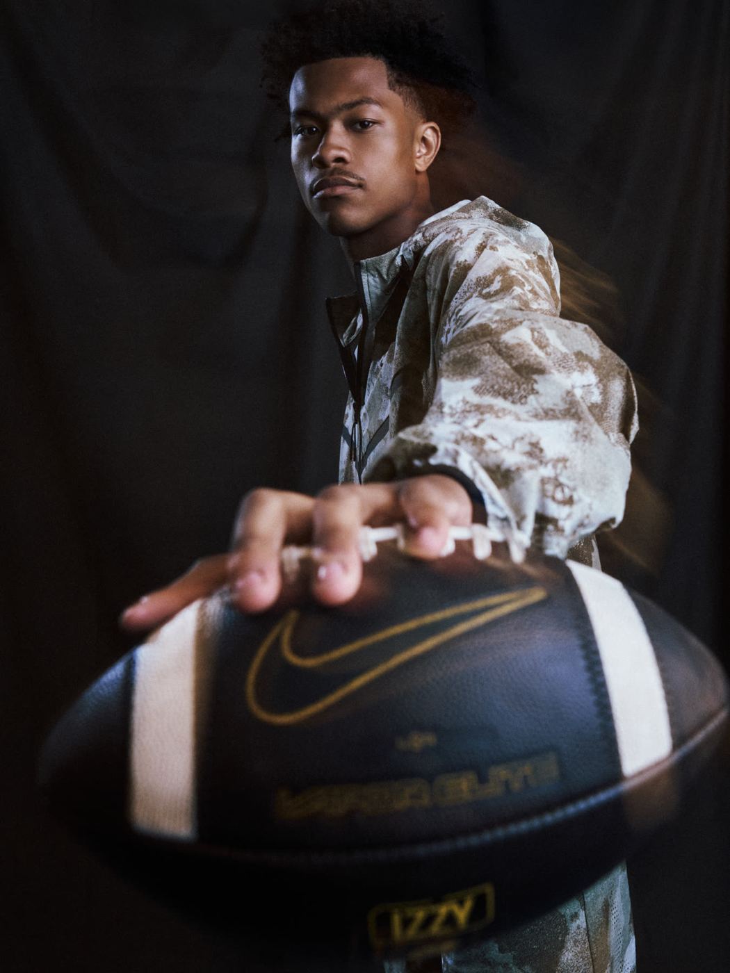 Quarterback holding a football toward the camera